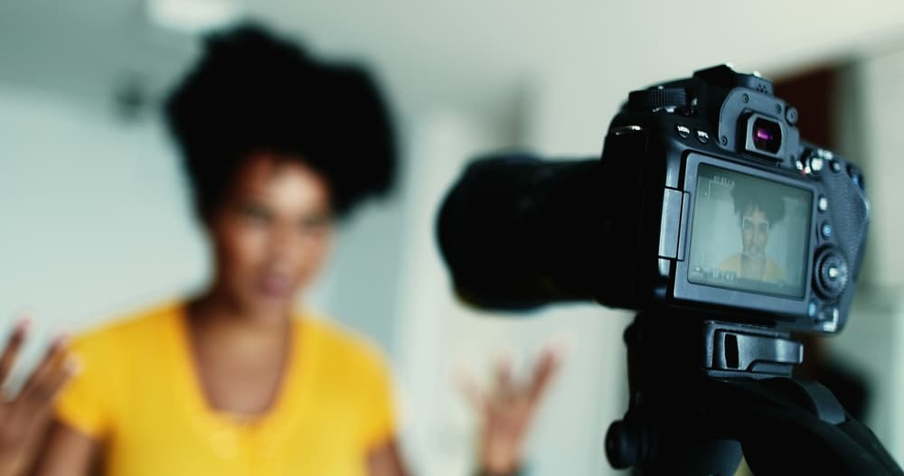 Black woman using camera to record testimonial for business